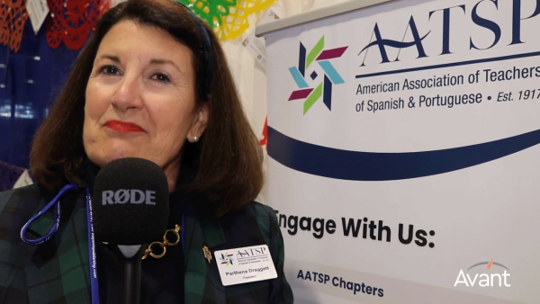 Woman with shoulder-length dark hair speaking in front of an AATSP banner.